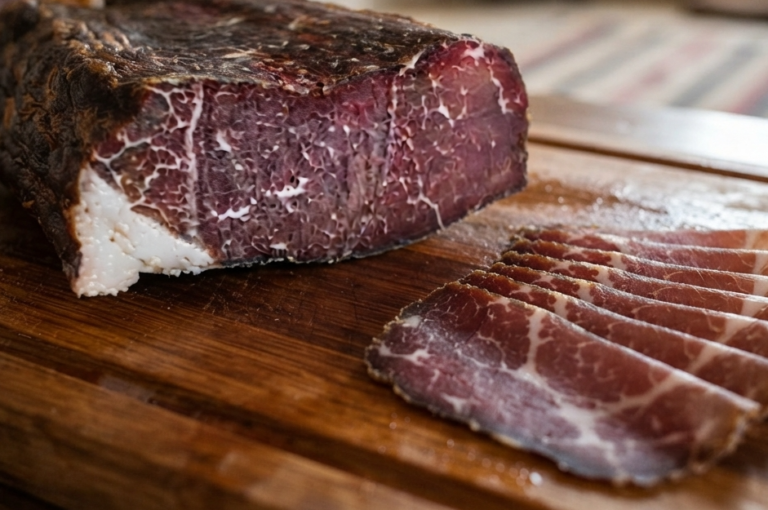 Visočka Pečenica aus Rindfleisch, angeschnitten und dünn mit Brot serviert
